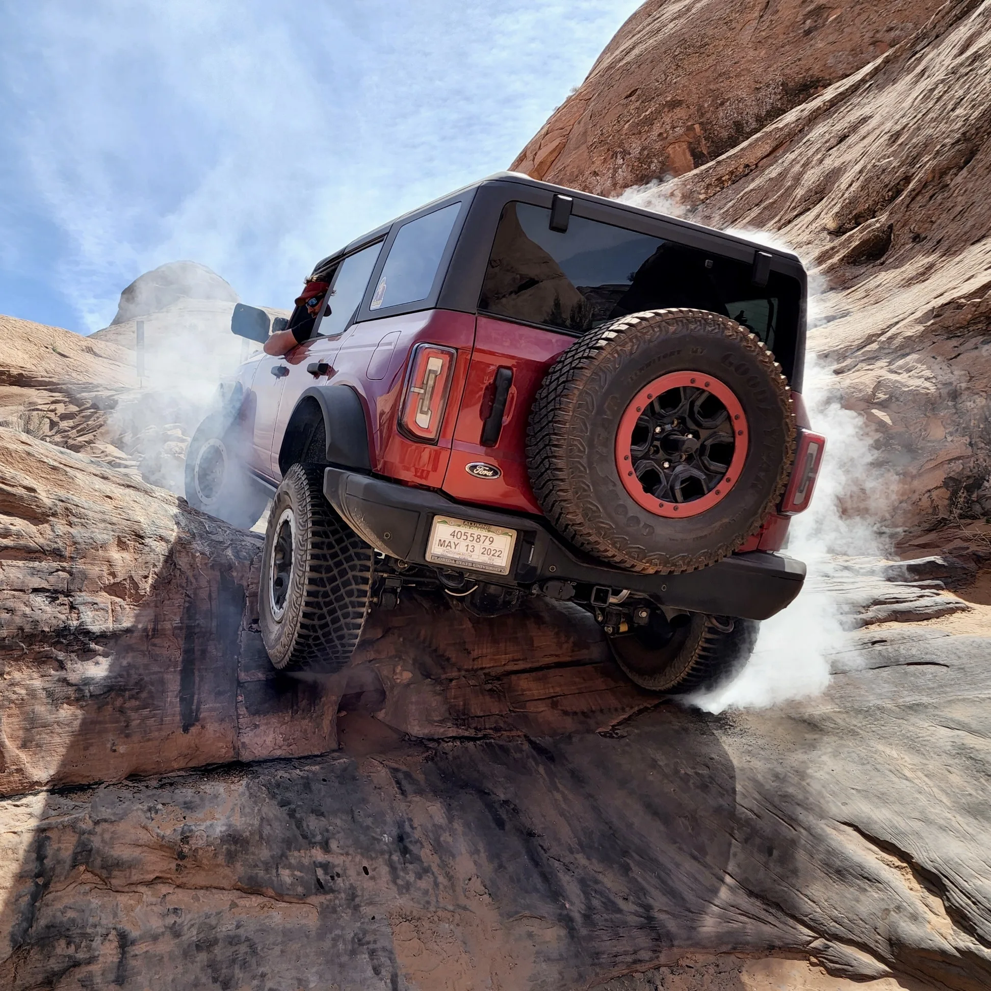 A Ford Bronco climbing a slickrock trail